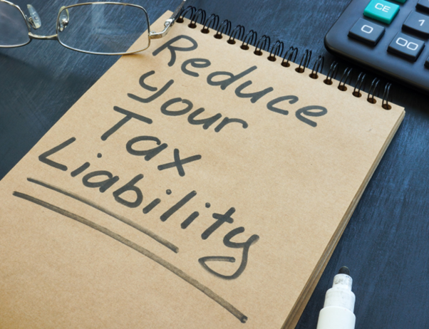 How to reduce tax on dividends concept with “reduce your tax liability” note on paper representing tax planning and financial strategy.