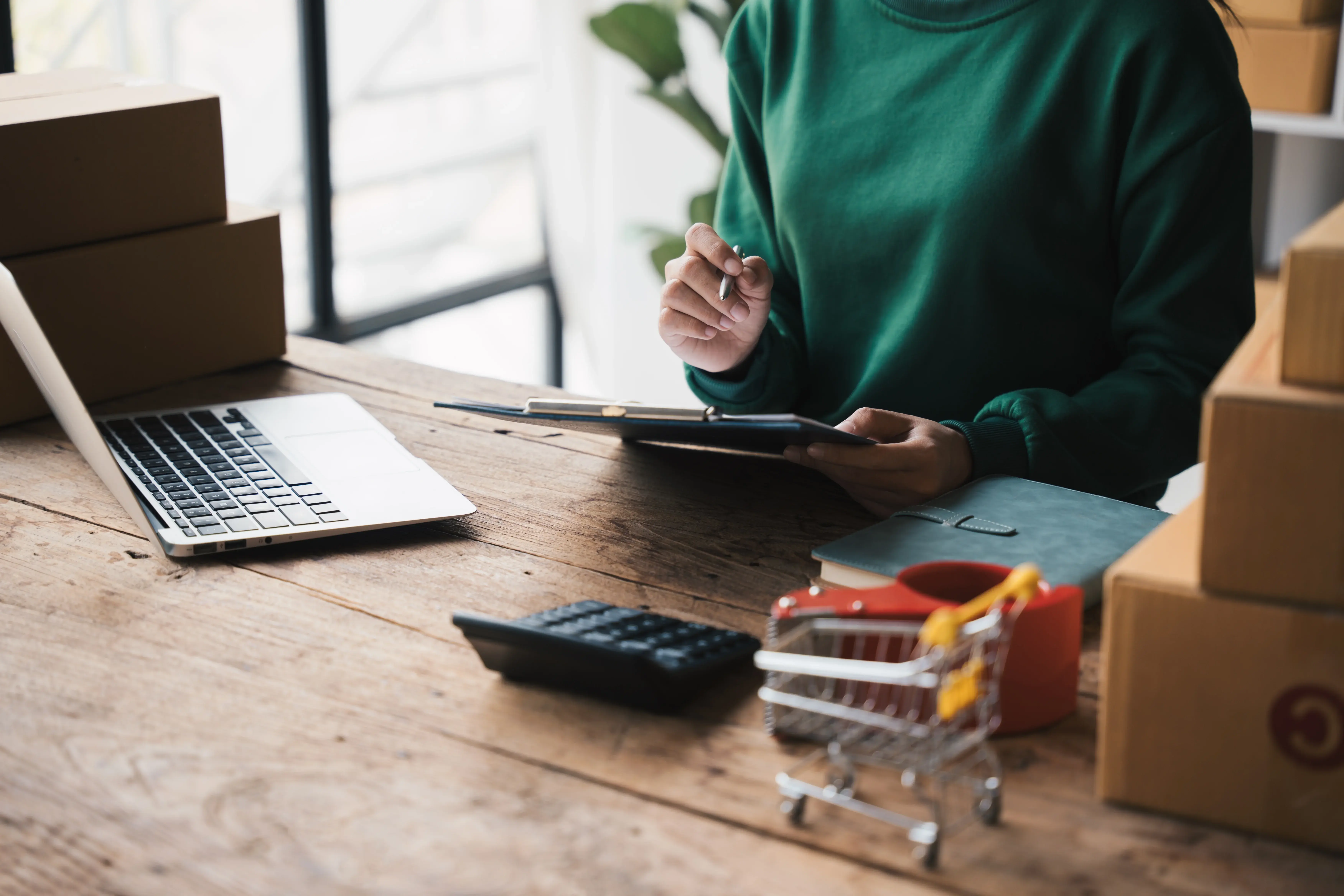E-commerce business owner reviewing online store finances and business performance at a desk.