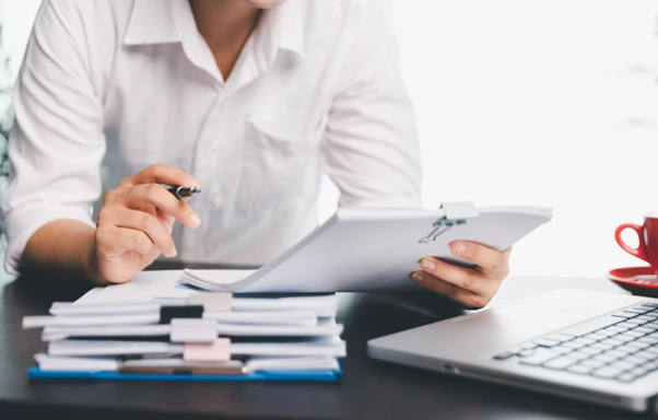 Businesswoman analysing financial reports and tax planning charts showing dividends from retained earnings in a limited company accounting concept.