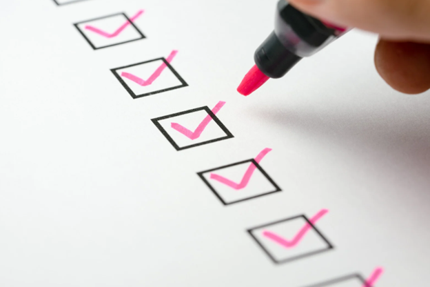A checklist document with boxes marked using a pink pen, representing outside IR35 contract compliance and HMRC preparation.