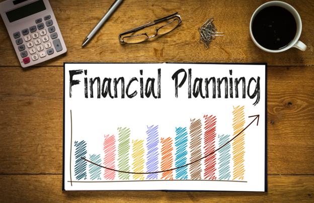 Financial planning documents and charts displayed on a desk, representing dividend tax brackets and personal financial management.