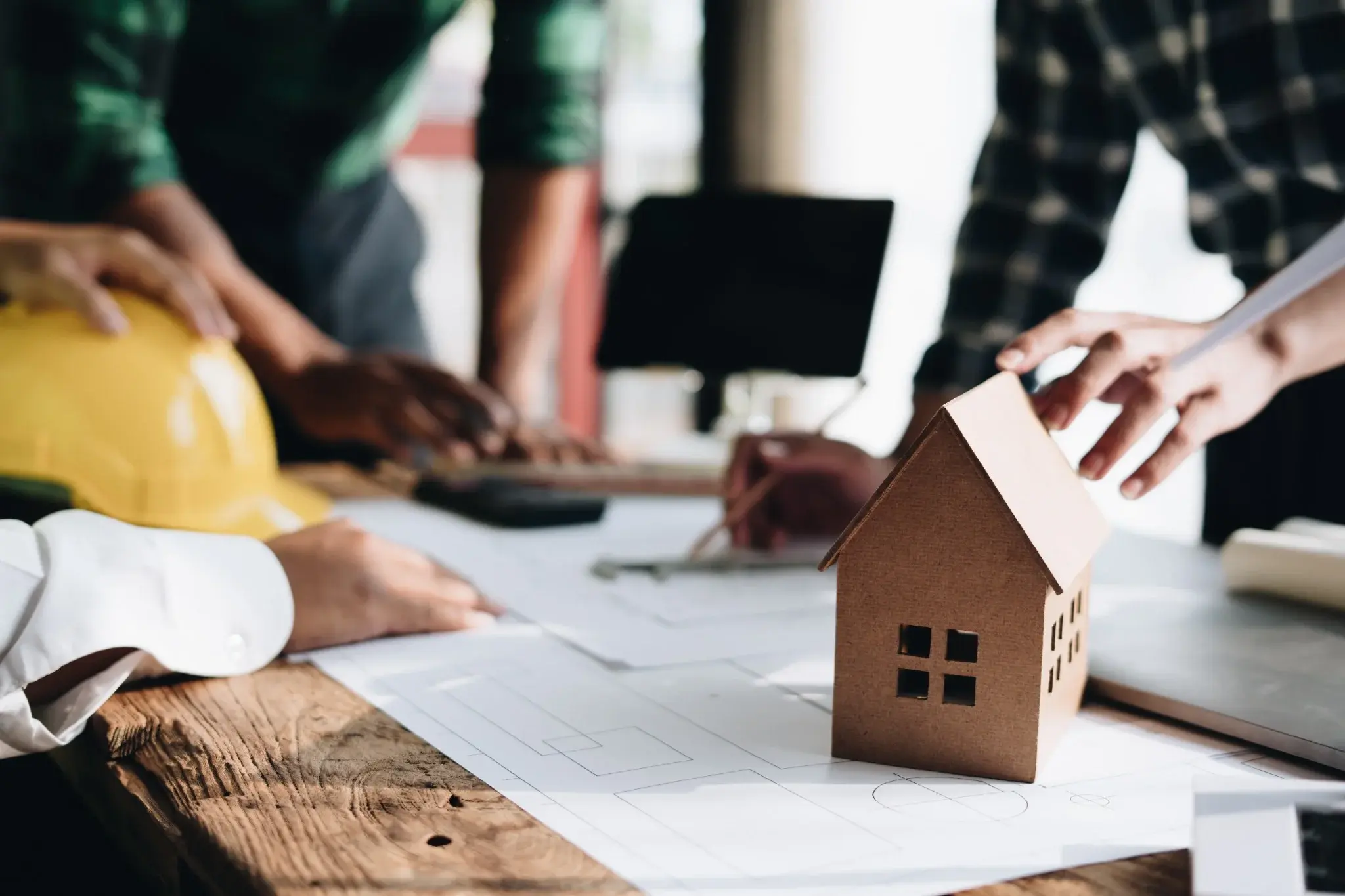 Property developers reviewing house plans and financial projections for a new residential development project.