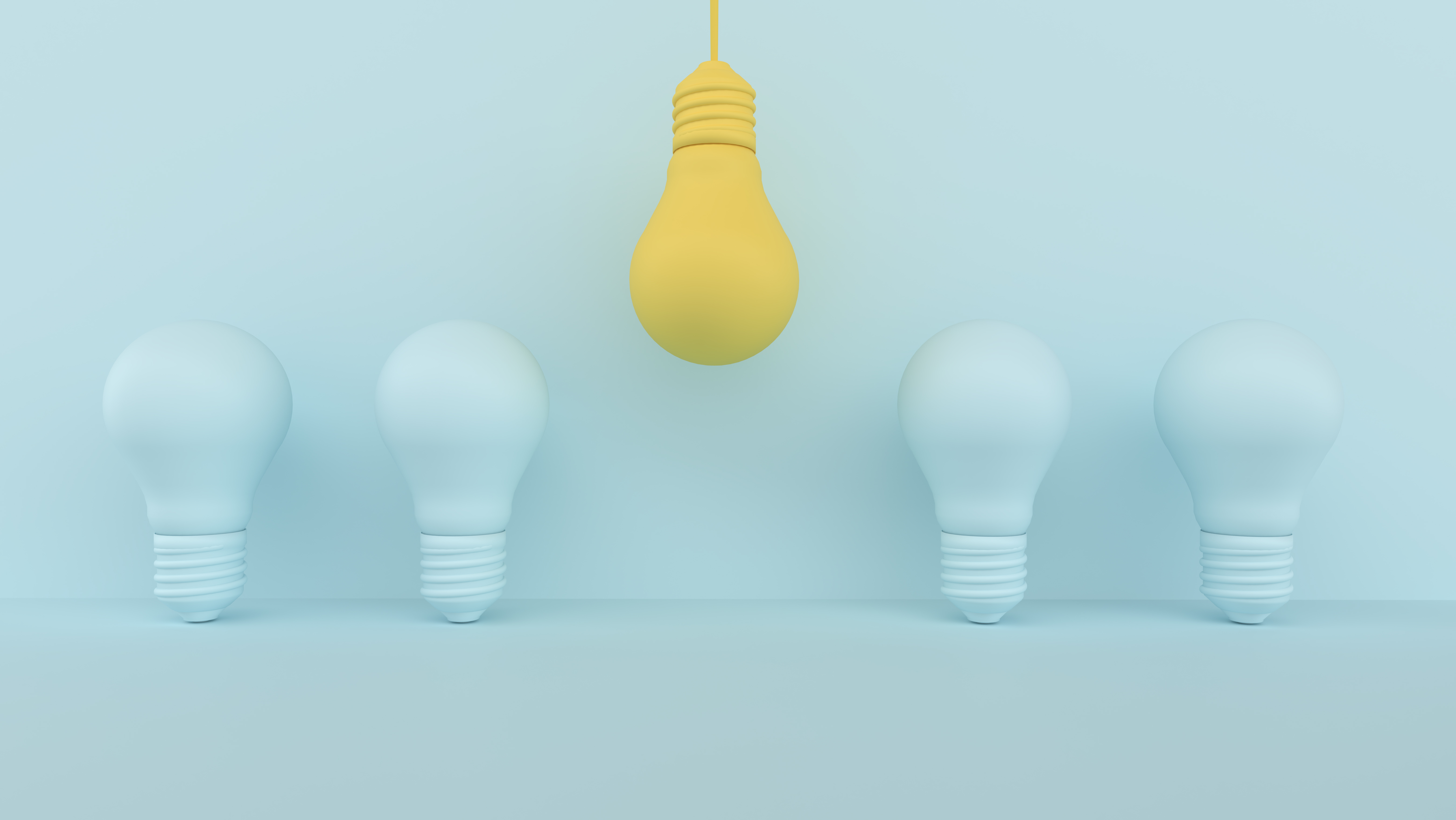 A set of four light blue lightbulbs on a light blue background, with a central hanging yellow lightbulb, conveying innovation.